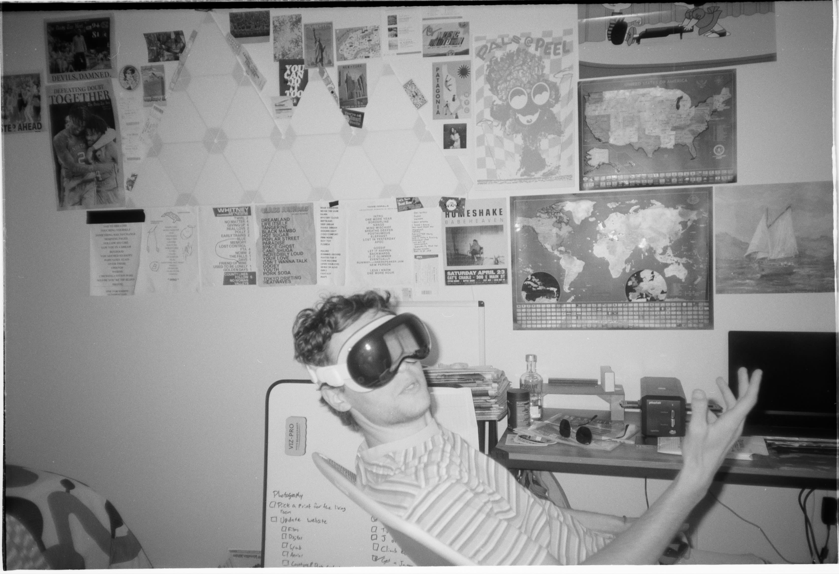 A friend in a striped shirt wearing a VR headset at a desk, gesturing