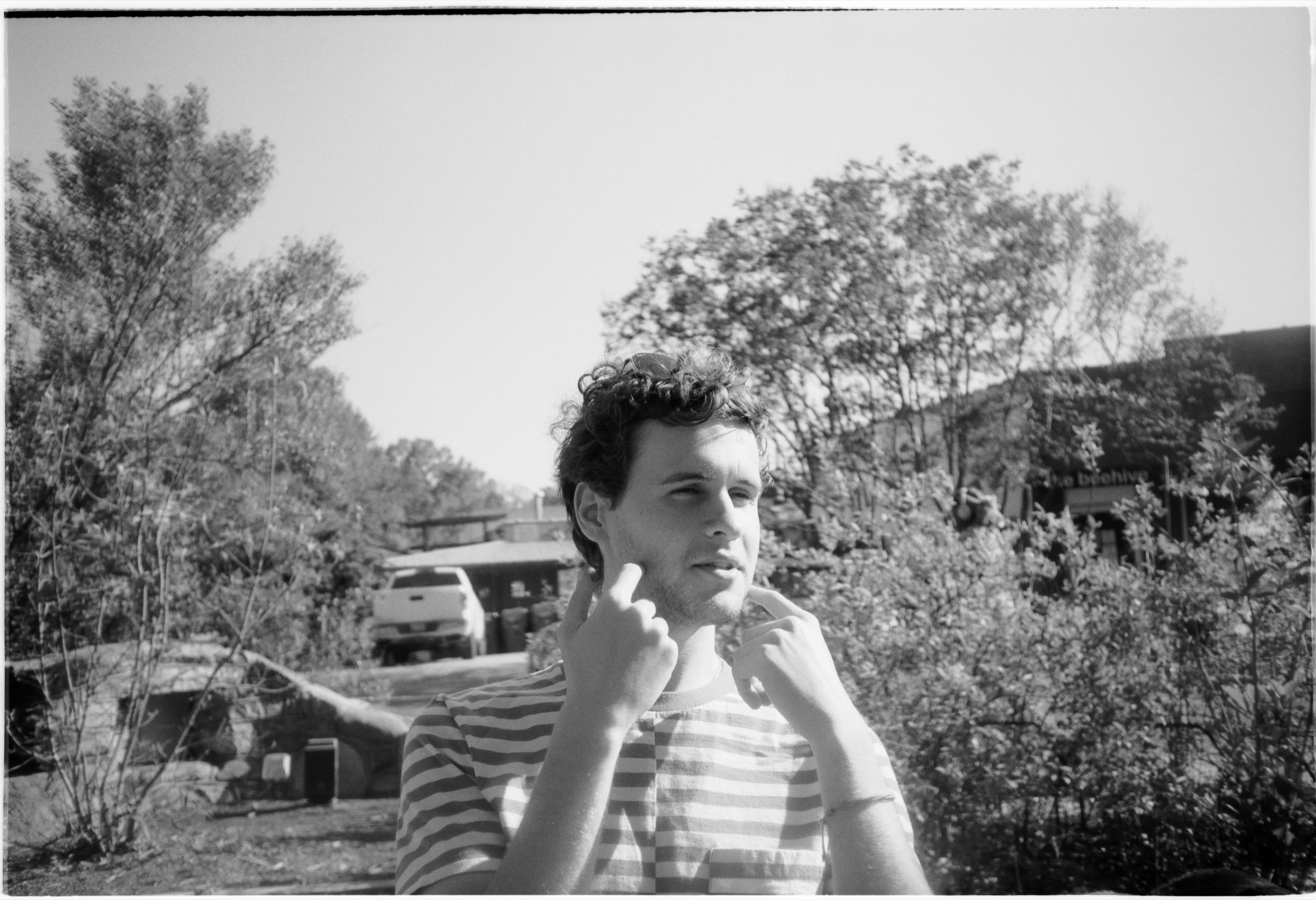 A friend in a striped shirt with fingers to their ears