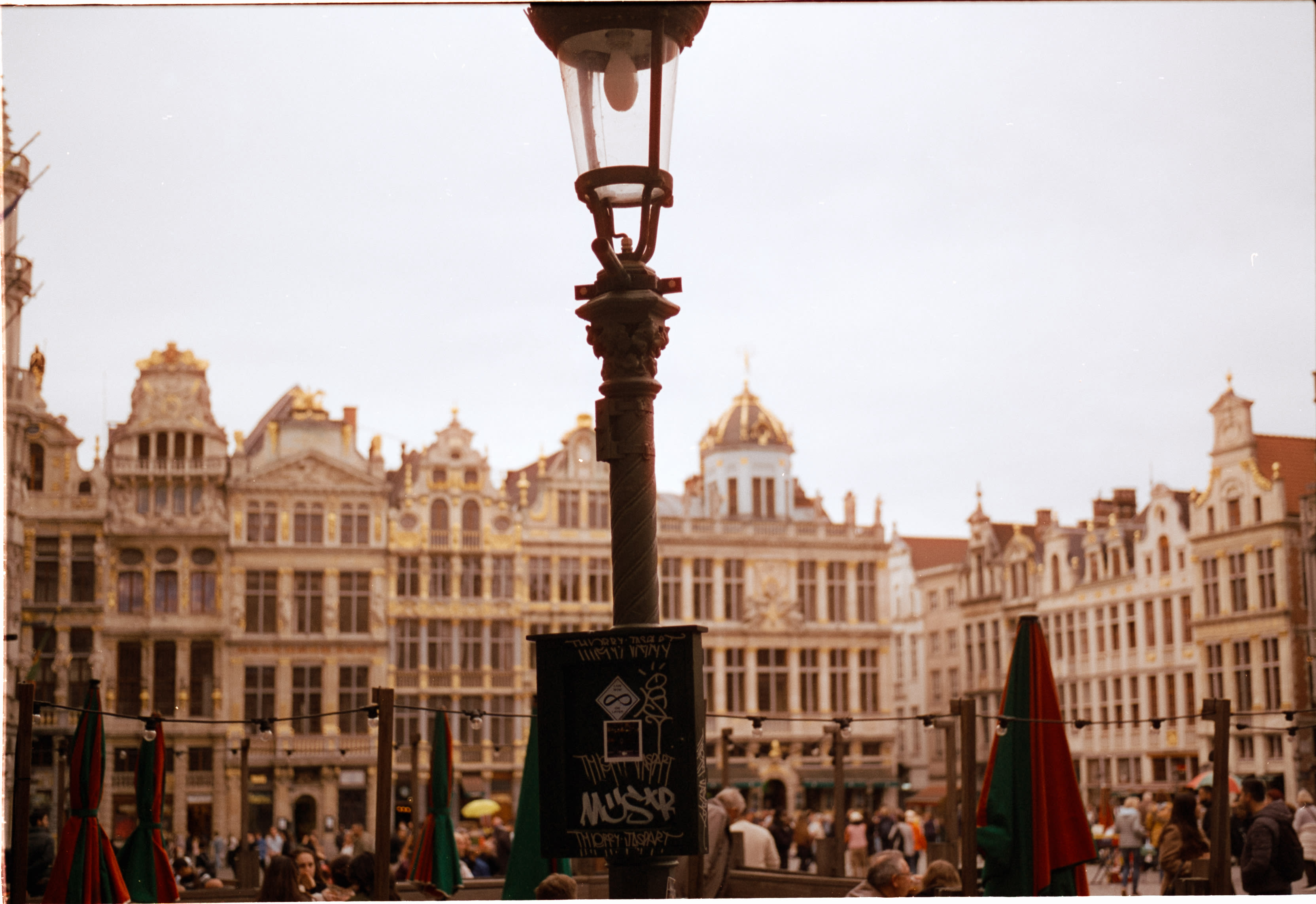 Guildhalls on the Grand-Place behind a lamppost and café umbrellas