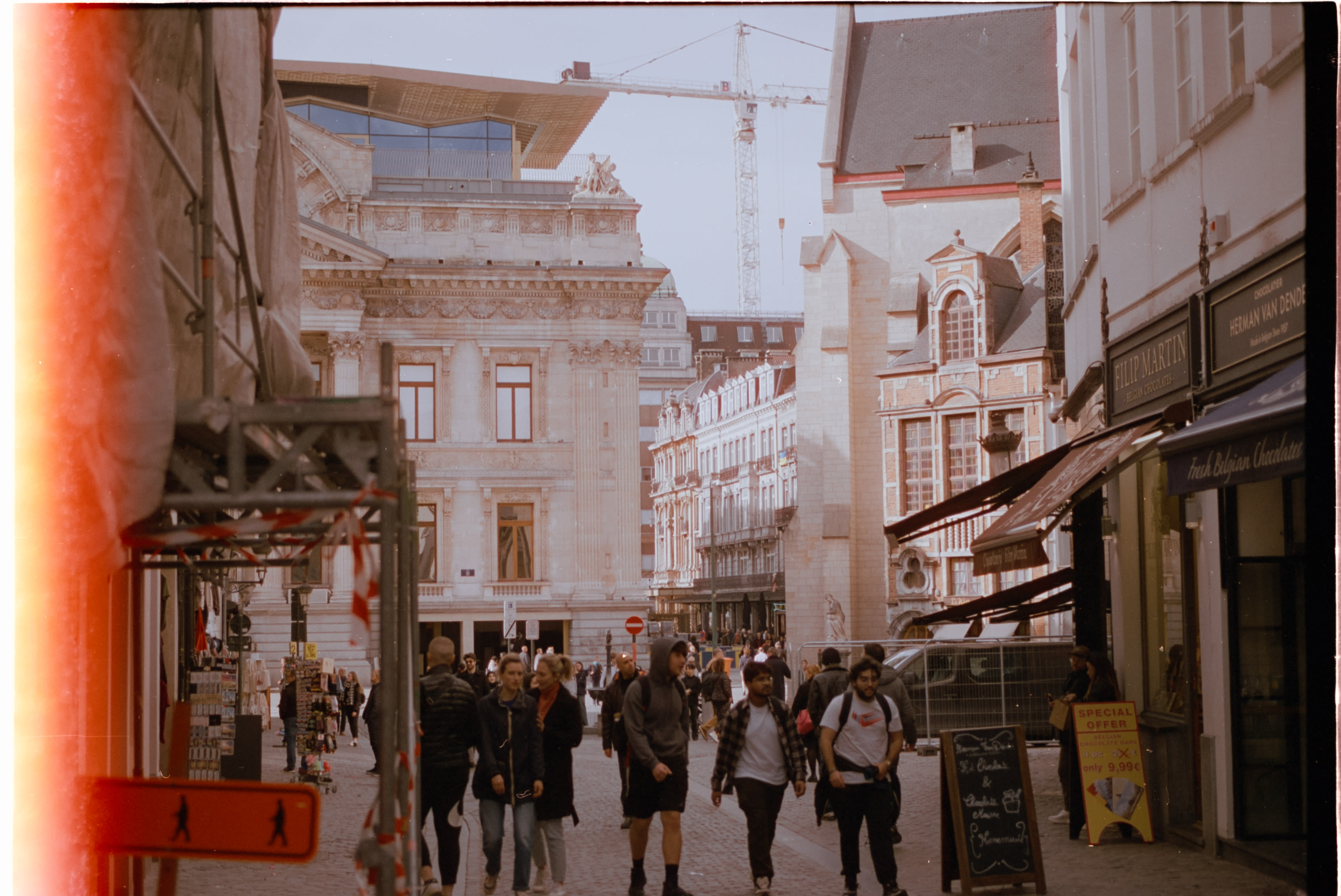 A busy shopping street, with a red light leak along one edge