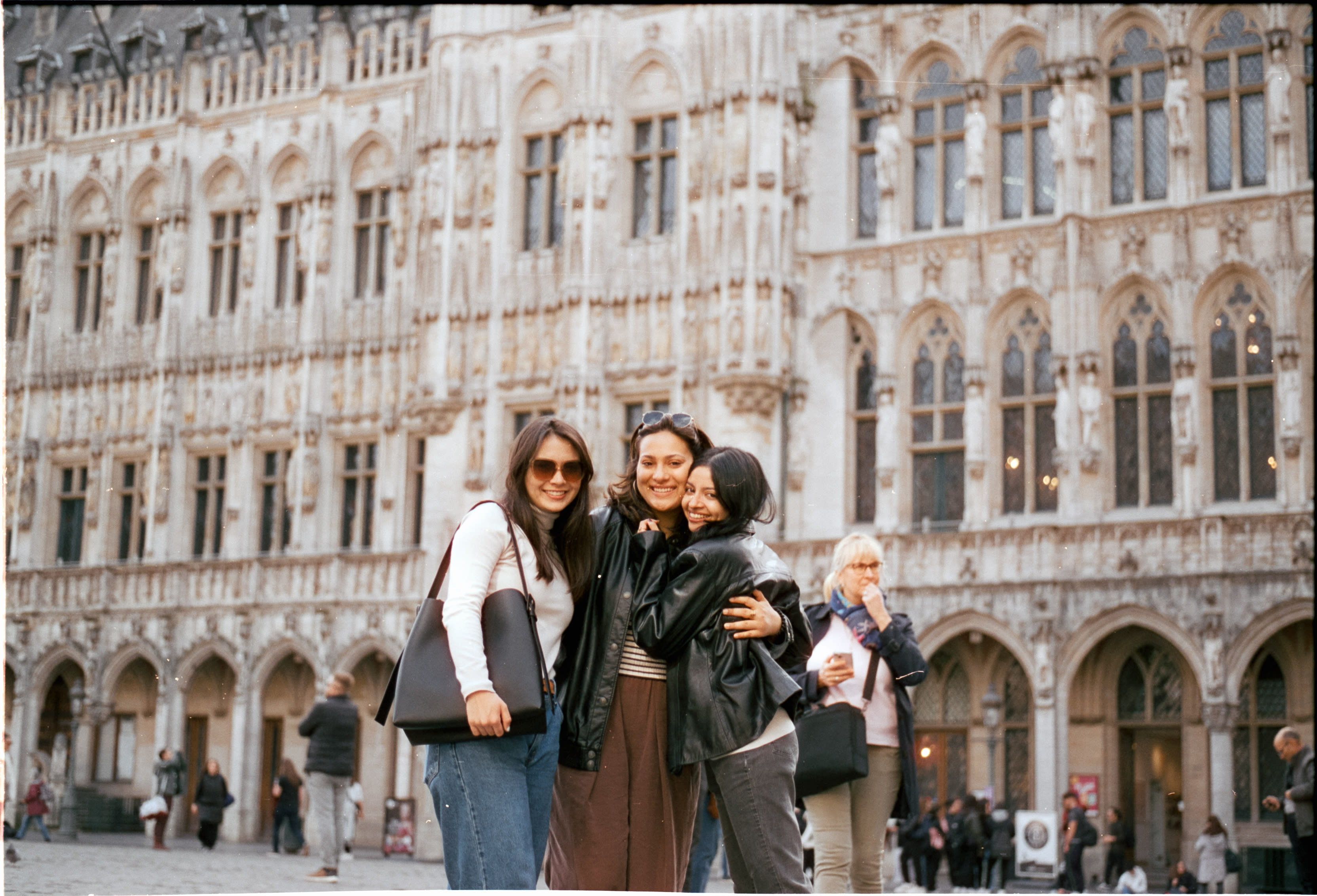 Three friends hugging in front of Brussels Town Hall
