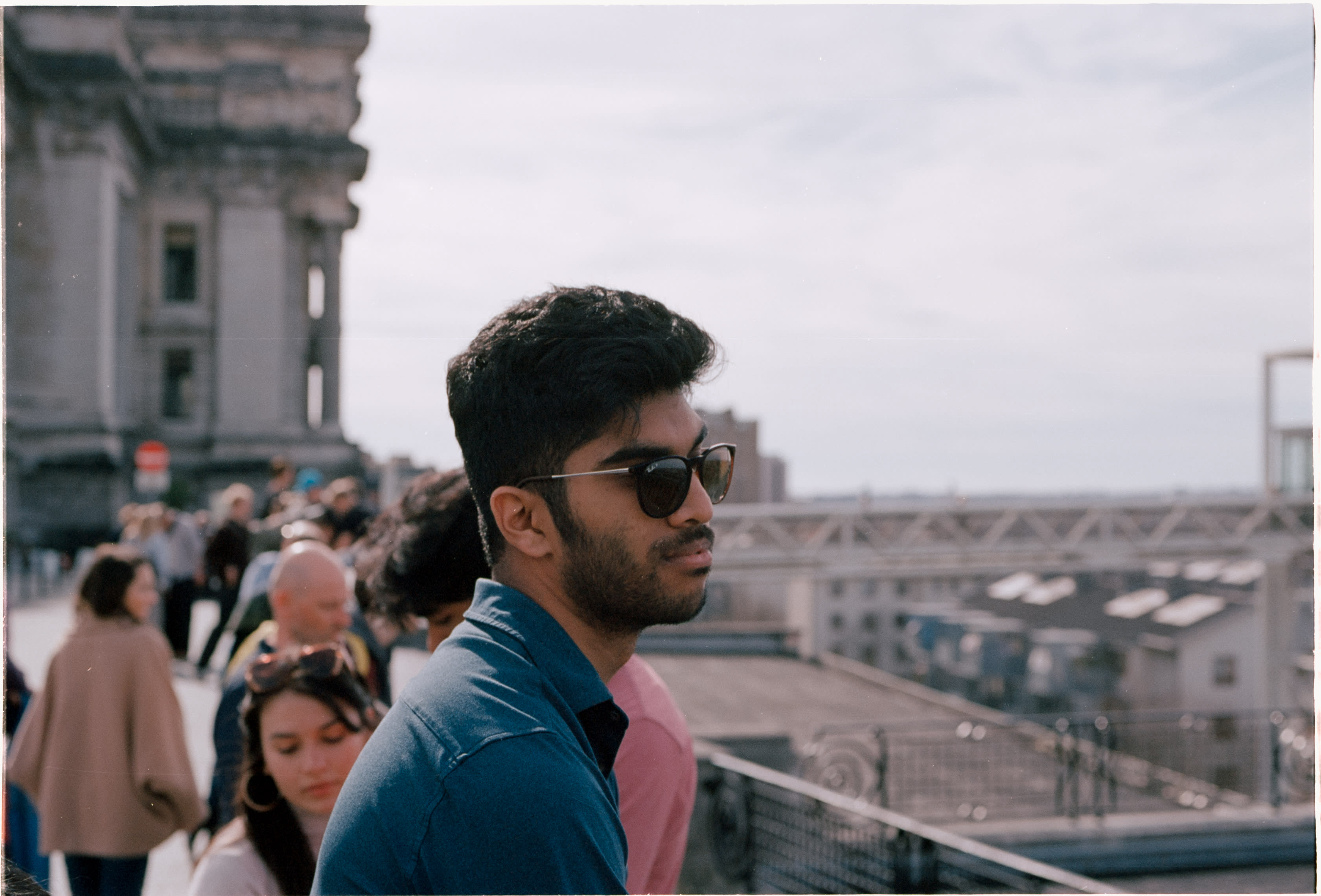 A friend in sunglasses looking out over the city from a crowded viewpoint