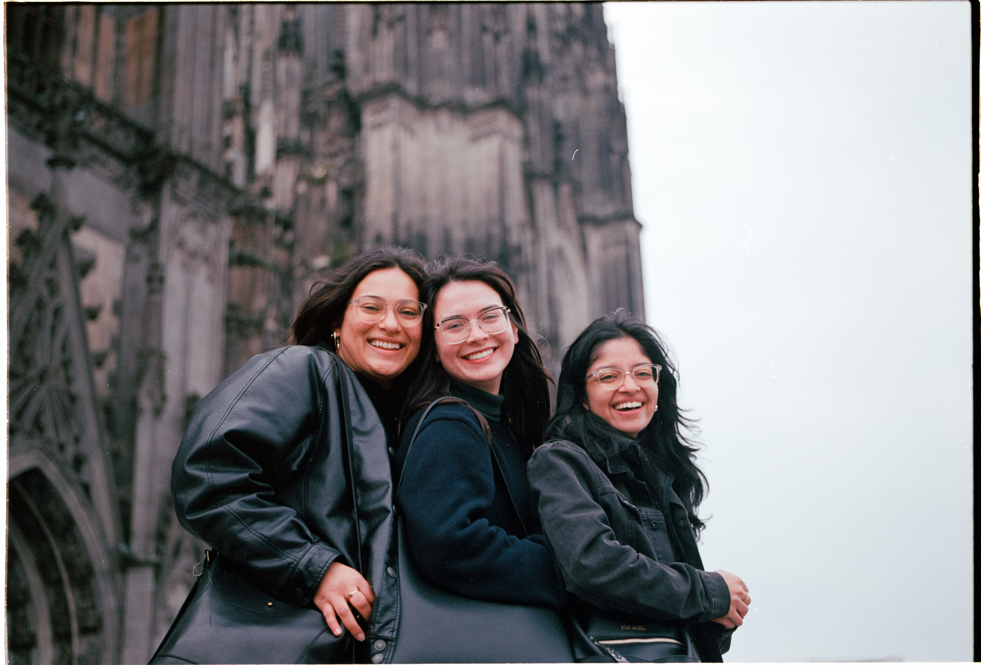 Three friends laughing in front of Cologne Cathedral