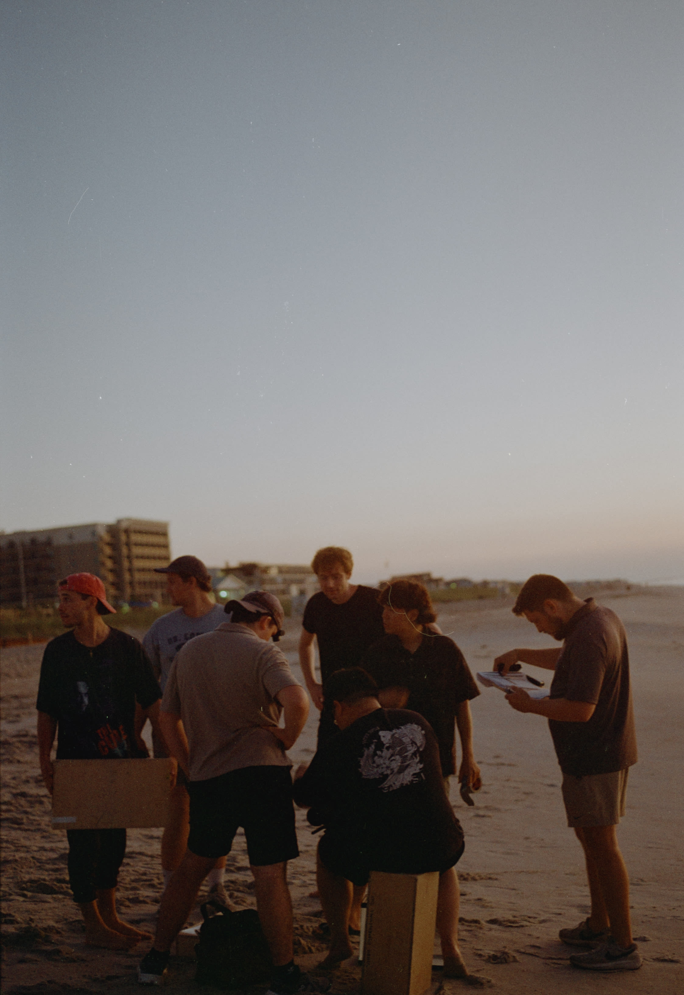 The crew huddled over a script on the beach at dusk