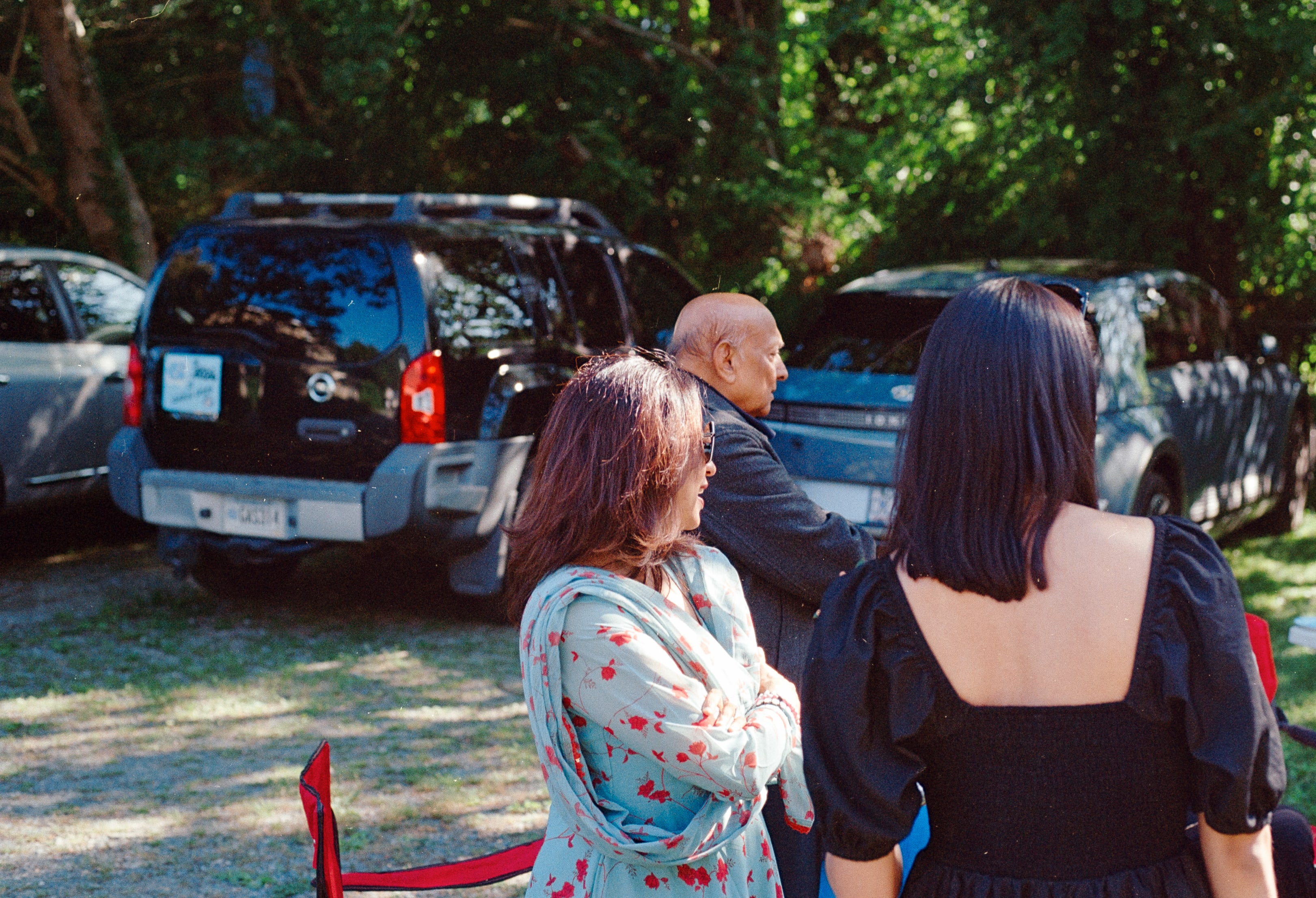 People talking in a shady parking lot