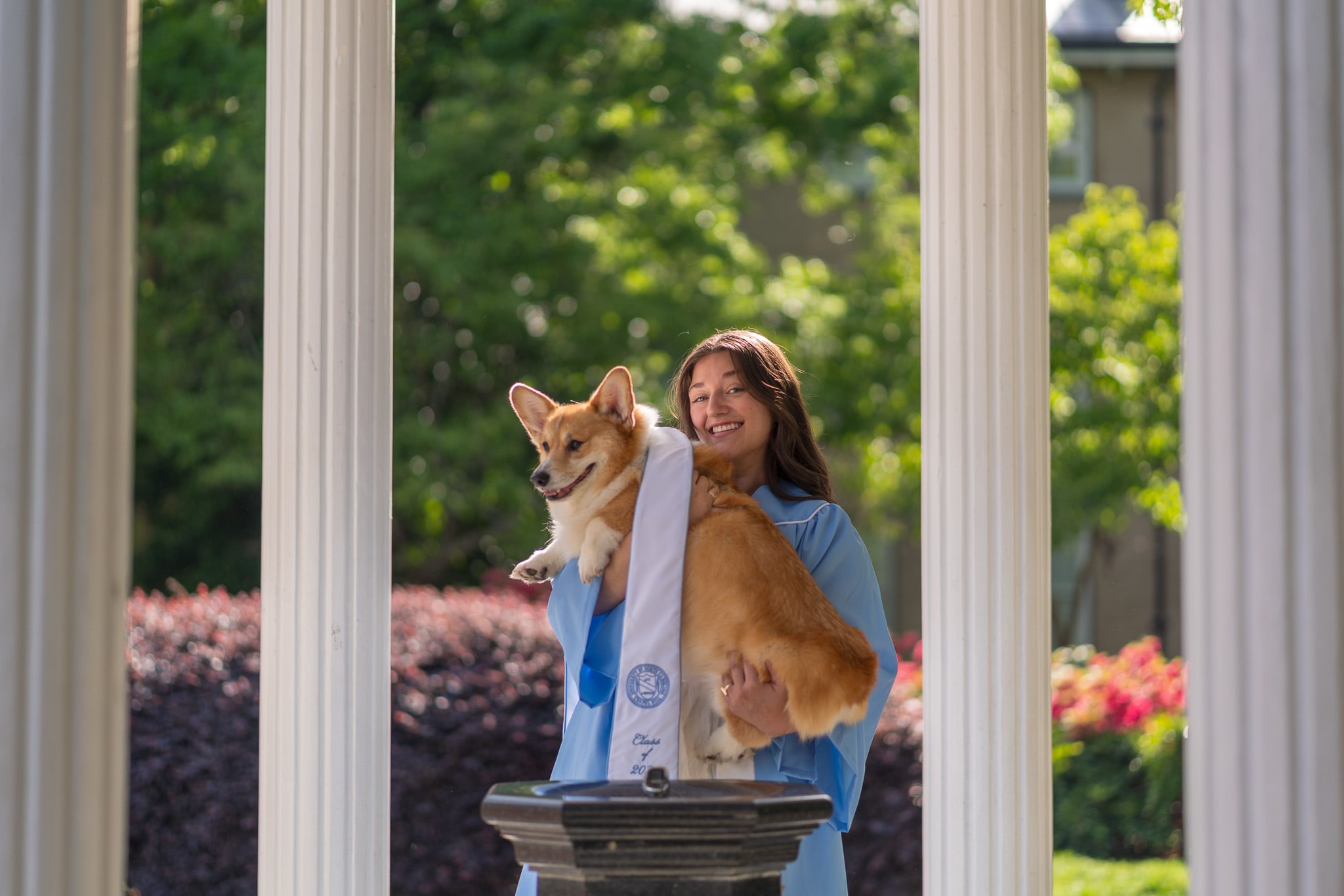 A grad and their dog at the Old Well