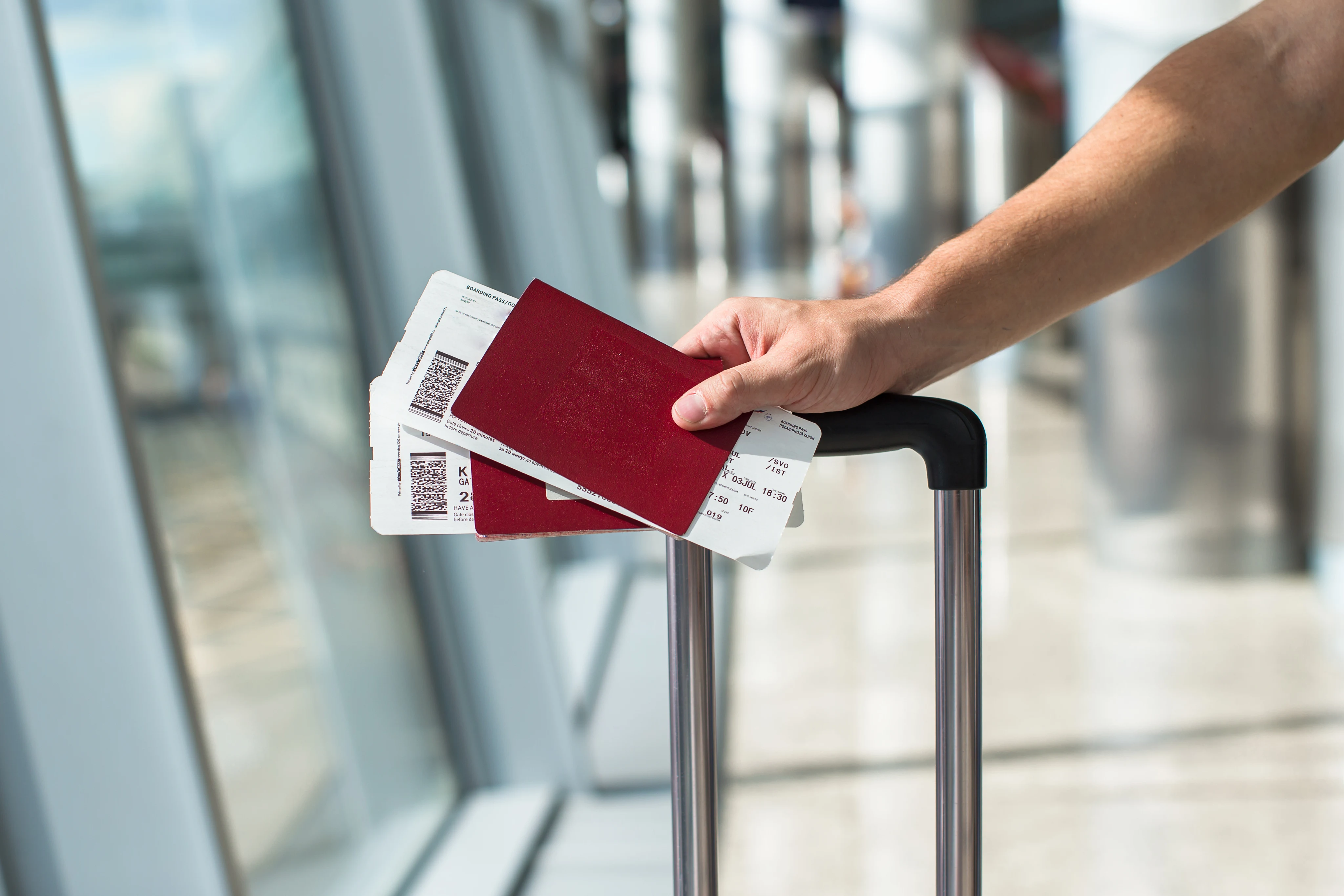 Hand holding passport and boarding passes