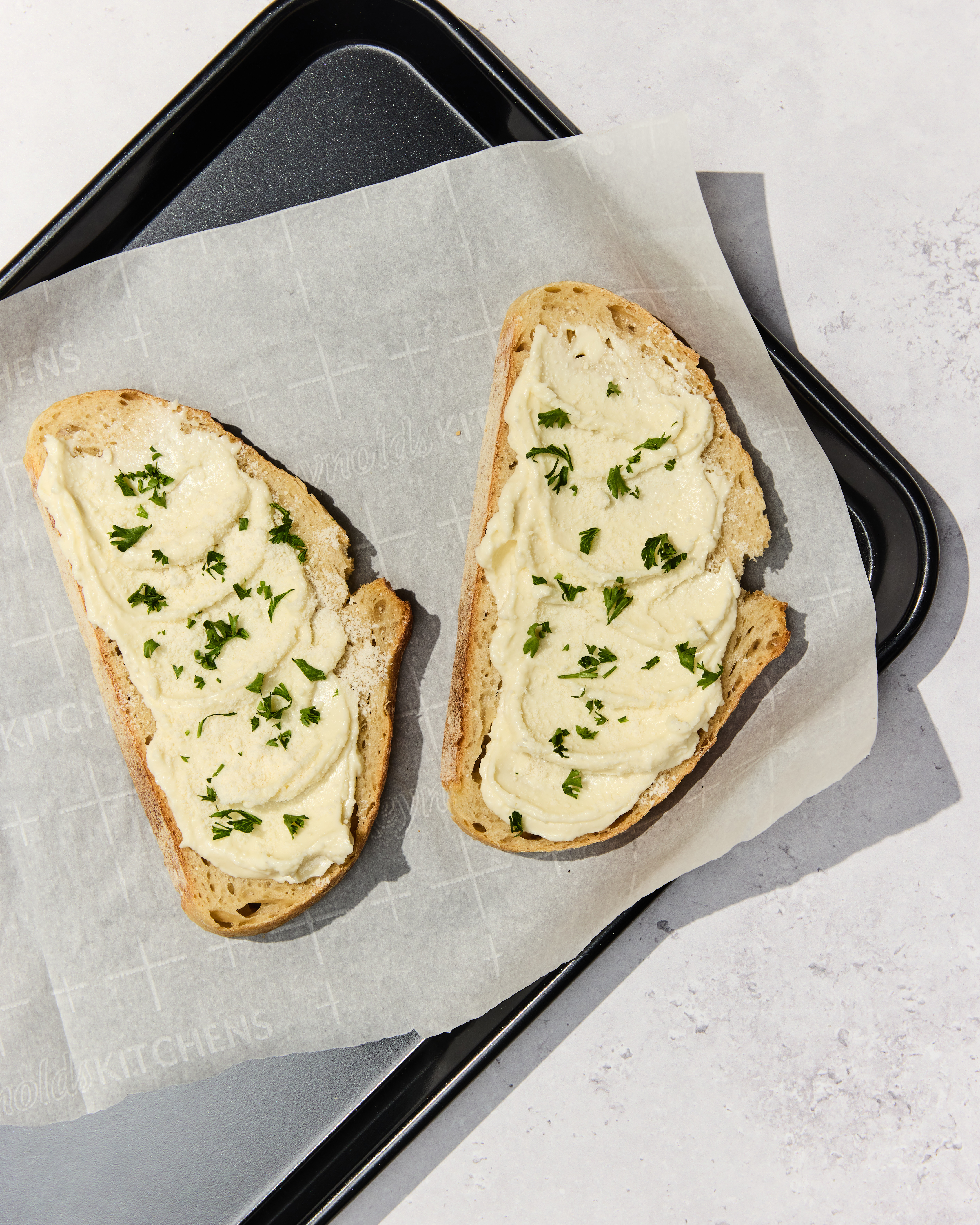 Sourdough bread with thick layer of original garlic spread, with parmesan cheese and parsley on top