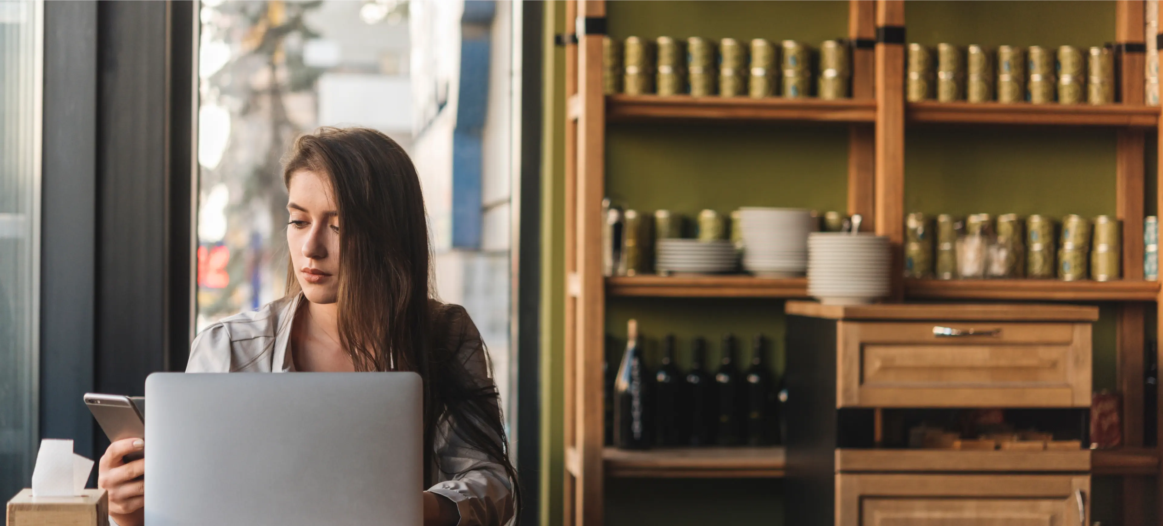 a woman using a computer and a cellphone