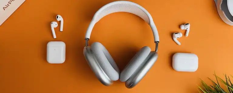 An orange table with some electronic devies on it, such as headphones