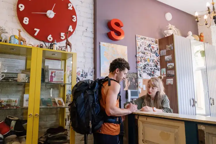 A guy checking into a hostel by the reception