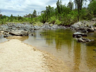 El río Los Reartes con su playa de arena y piedras