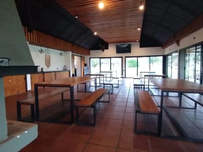 Interior del salón comedor de Corral de Pirca con mesas de madera