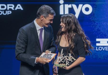 Amaia entrega a Sánchez el cartel 'Decreto Maricarmen' en los Premios Vanguardia