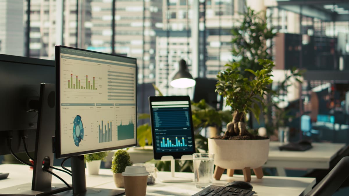Espacio de trabajo moderno con dashboards de análisis de datos en pantallas