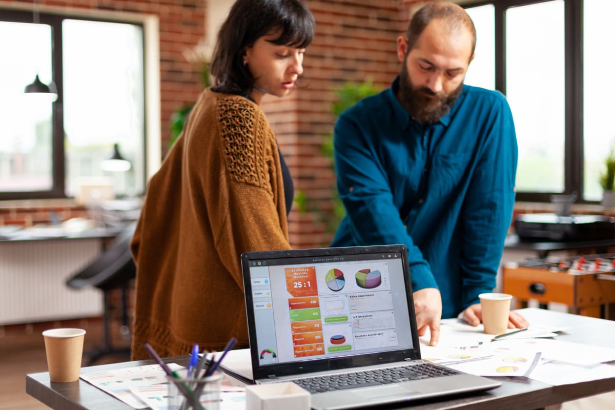Equipo de trabajo analizando estrategia de contenidos B2B en documentos y laptop