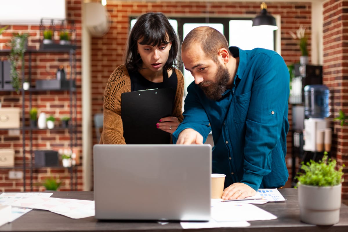 Equipo de negocios revisando estrategia digital y métricas en laptop