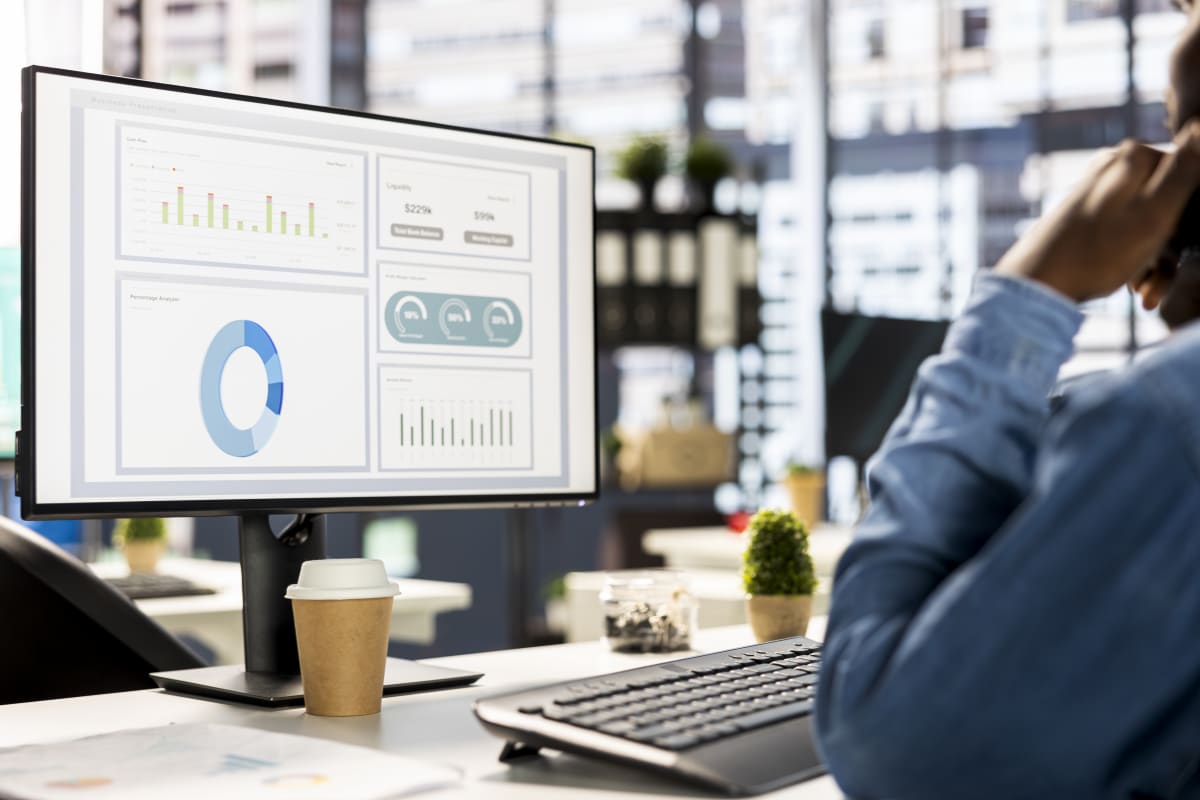 Empresario analizando métricas e informes de desempeño comercial en una oficina moderna.