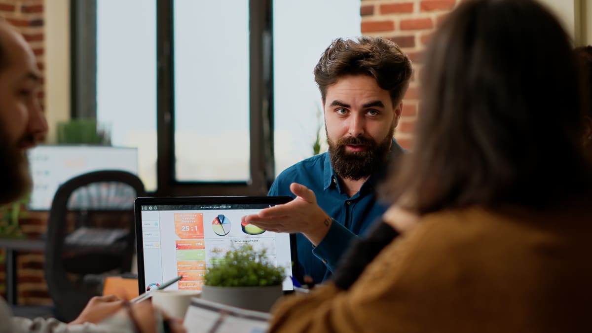 Equipo comercial revisando datos de prospectos en laptop con gráficos de resultados de campaña B2B