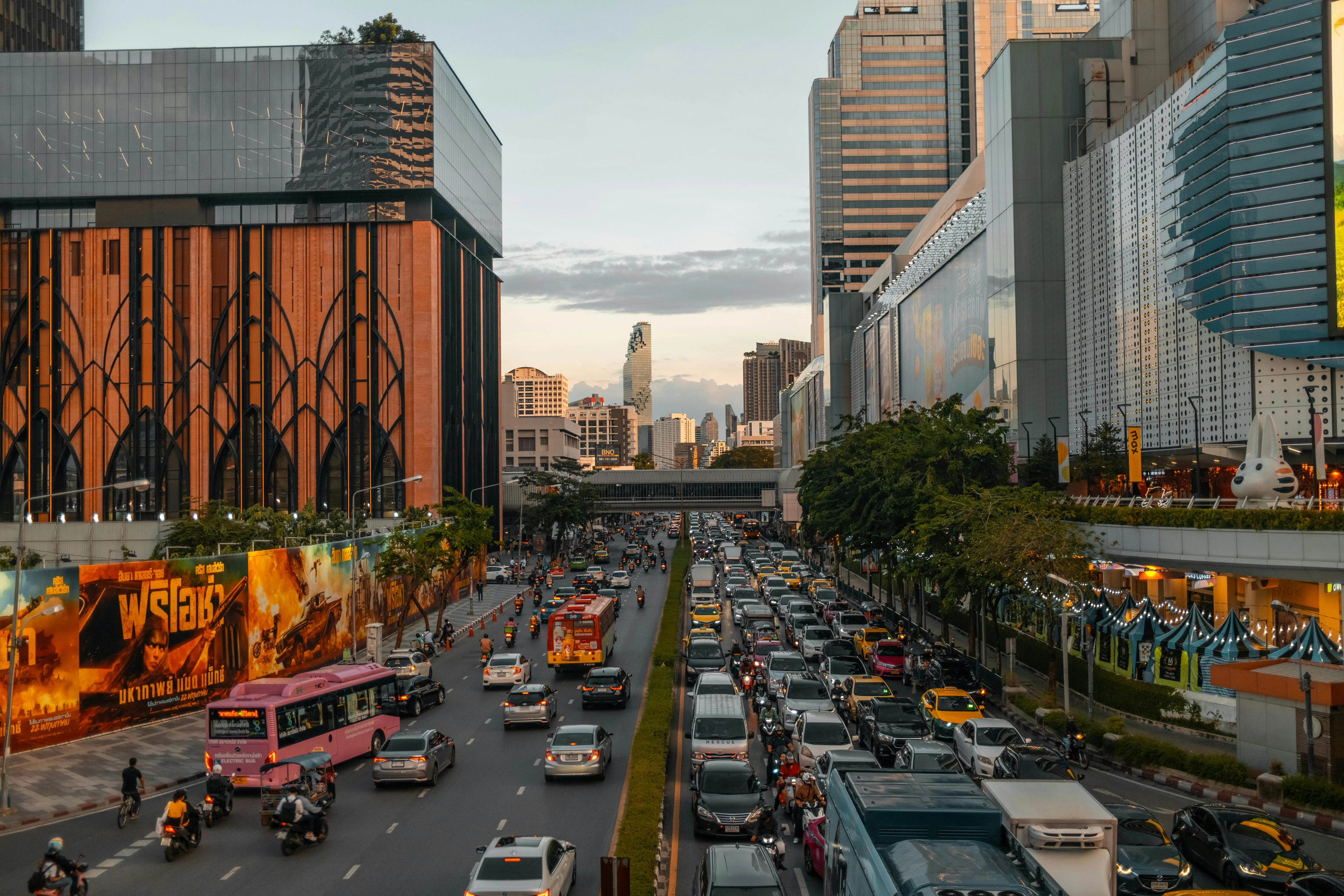Vibrant cityscape of Bangkok at dusk with bustling traffic and skyline in view.