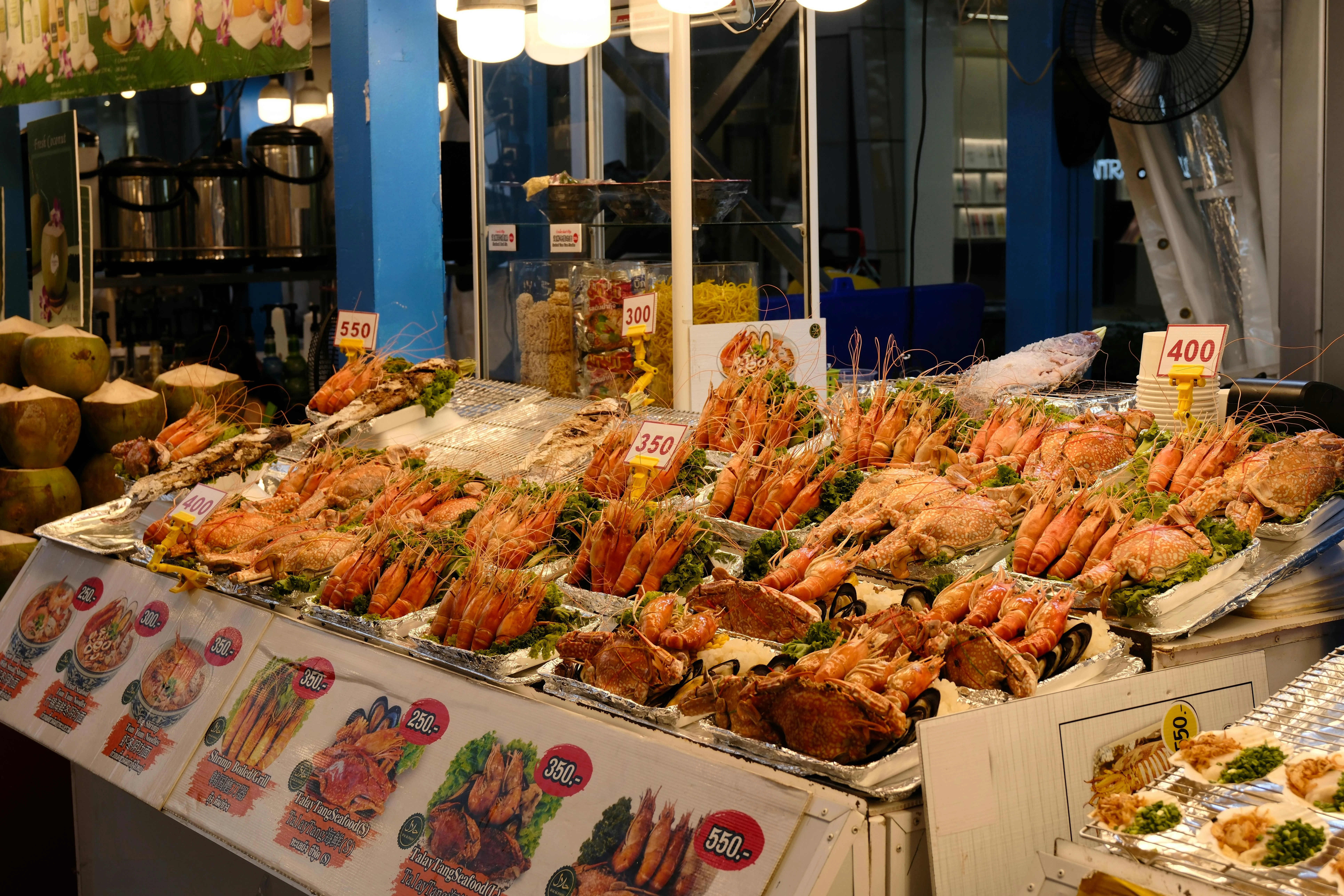 Vibrant seafood stall with prawns and fish on display in an outdoor night market setting