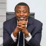 image of Victor Athe wearing a suit with his two hands supporting his chin.