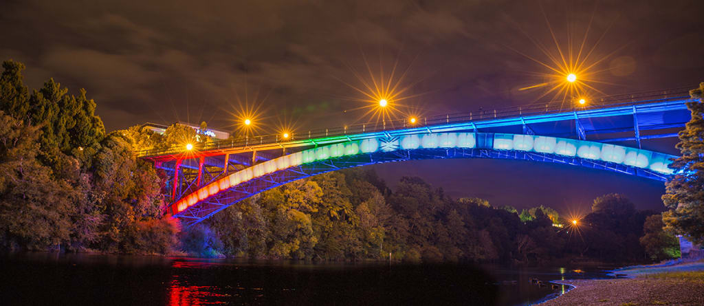 Hamilton Bridge in NZ lit up with LGBTQ colours