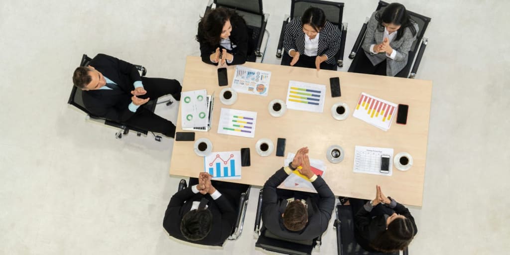 a top down view of a group of people organising files and notes on a page