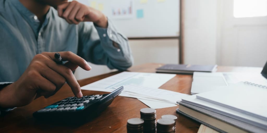 man sat at desk working out a budget