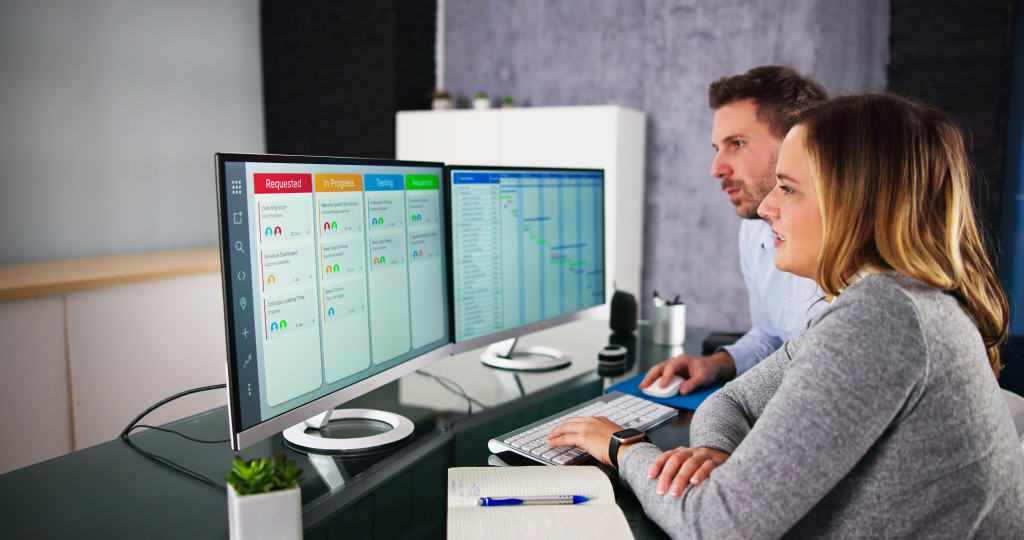 man and woman looking at series of screens for permit licensing software