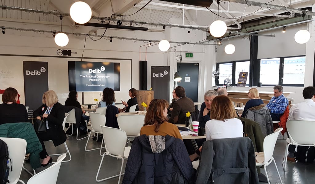 Photo of venue with people sat chatting ahead of event starting