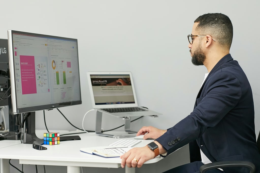 man sat at computer looking at a permit regulation process