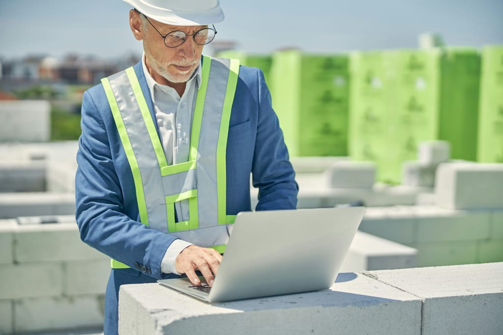 construction worker looking on laptop