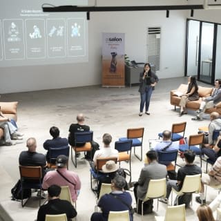 A speaker presenting to a seated audience in the Event Hall