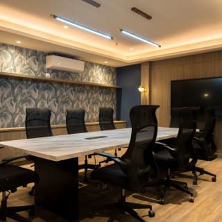 The Boardroom: a long marble table and a large wall screen