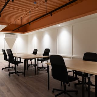 A second-floor private office with long desks under arched windows