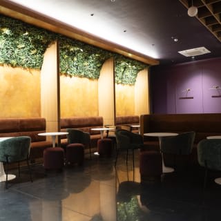 The ground-floor hot desk lounge with banquettes and a green wall