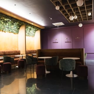The ground-floor lounge, purple and gold walls with café tables