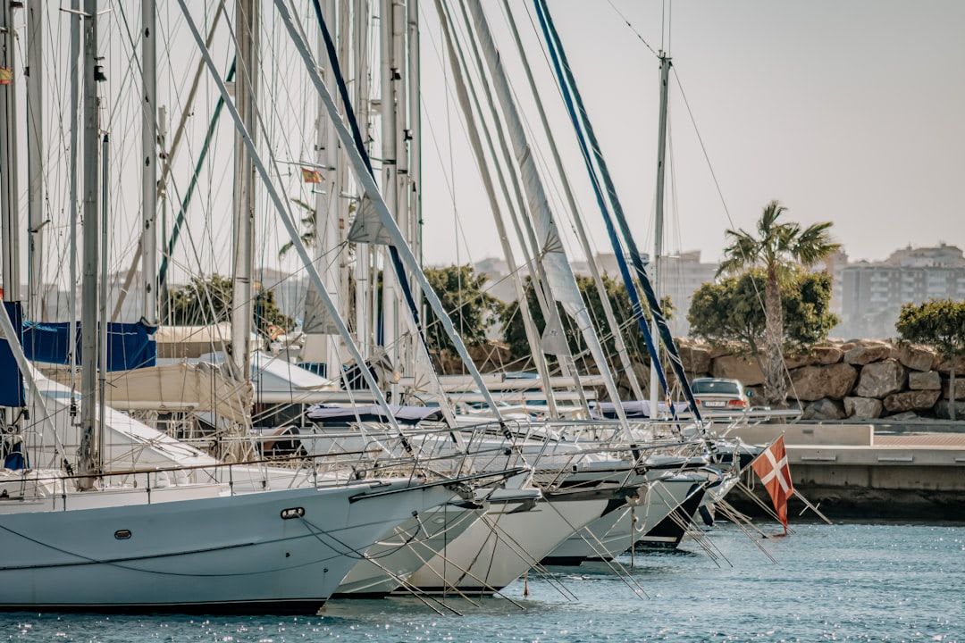 Velero y yates en la marina de Alicante con el Mediterráneo de fondo