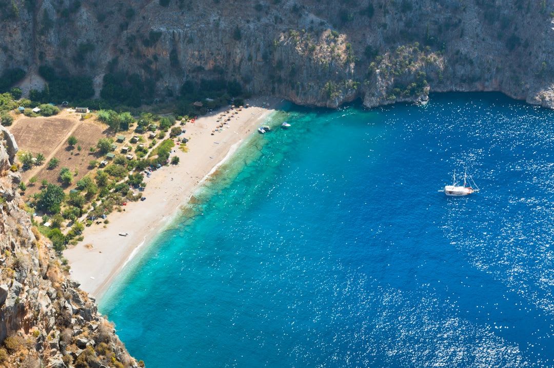 Cala tranquila con velero fondeado en aguas turquesas del Mediterráneo