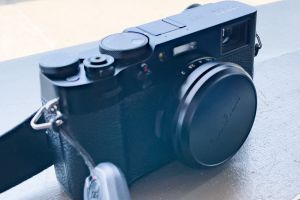 Fuji X100V camera with lens cap and strap