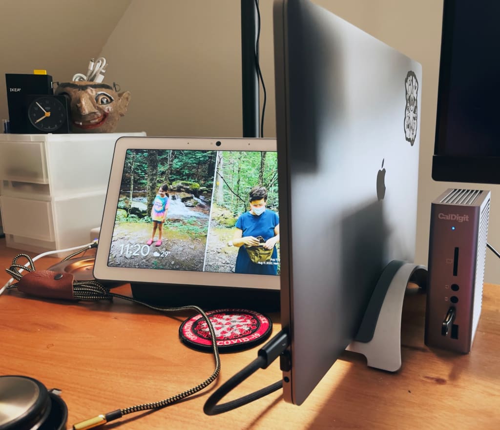 Desk with Google Home, laptop, and monitor