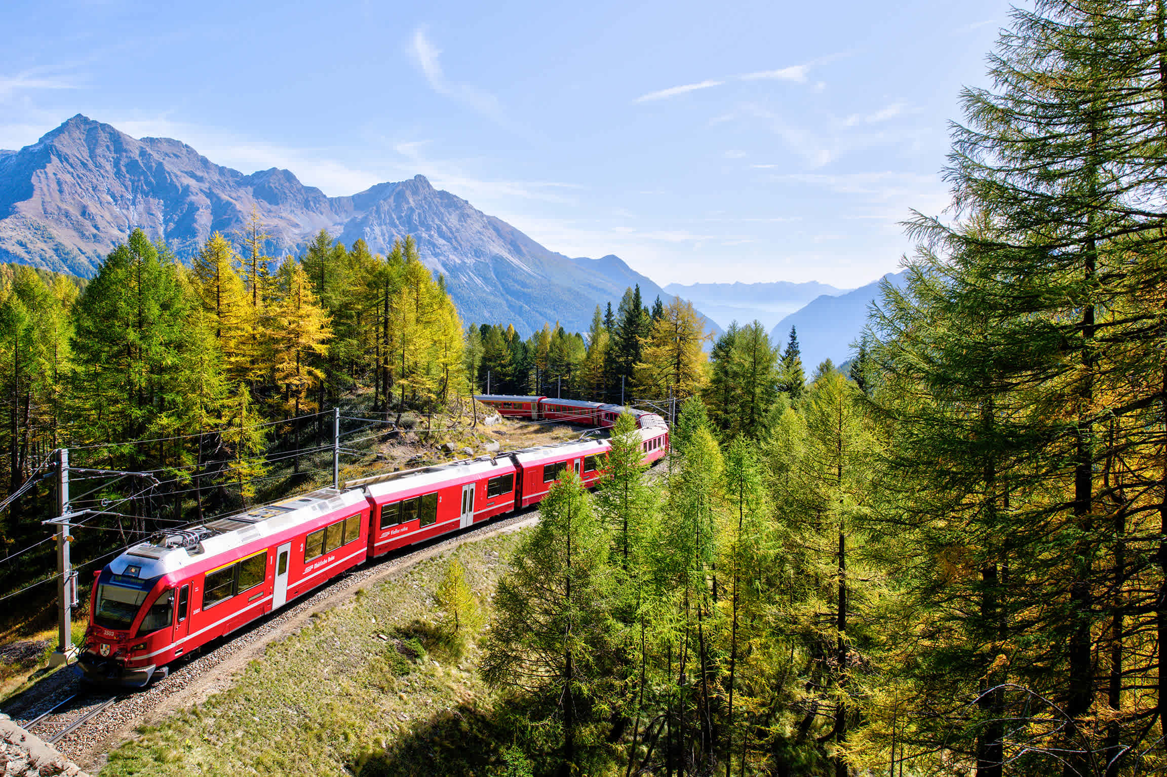 Ein Zug fährt durch eine hügelige Landschaft