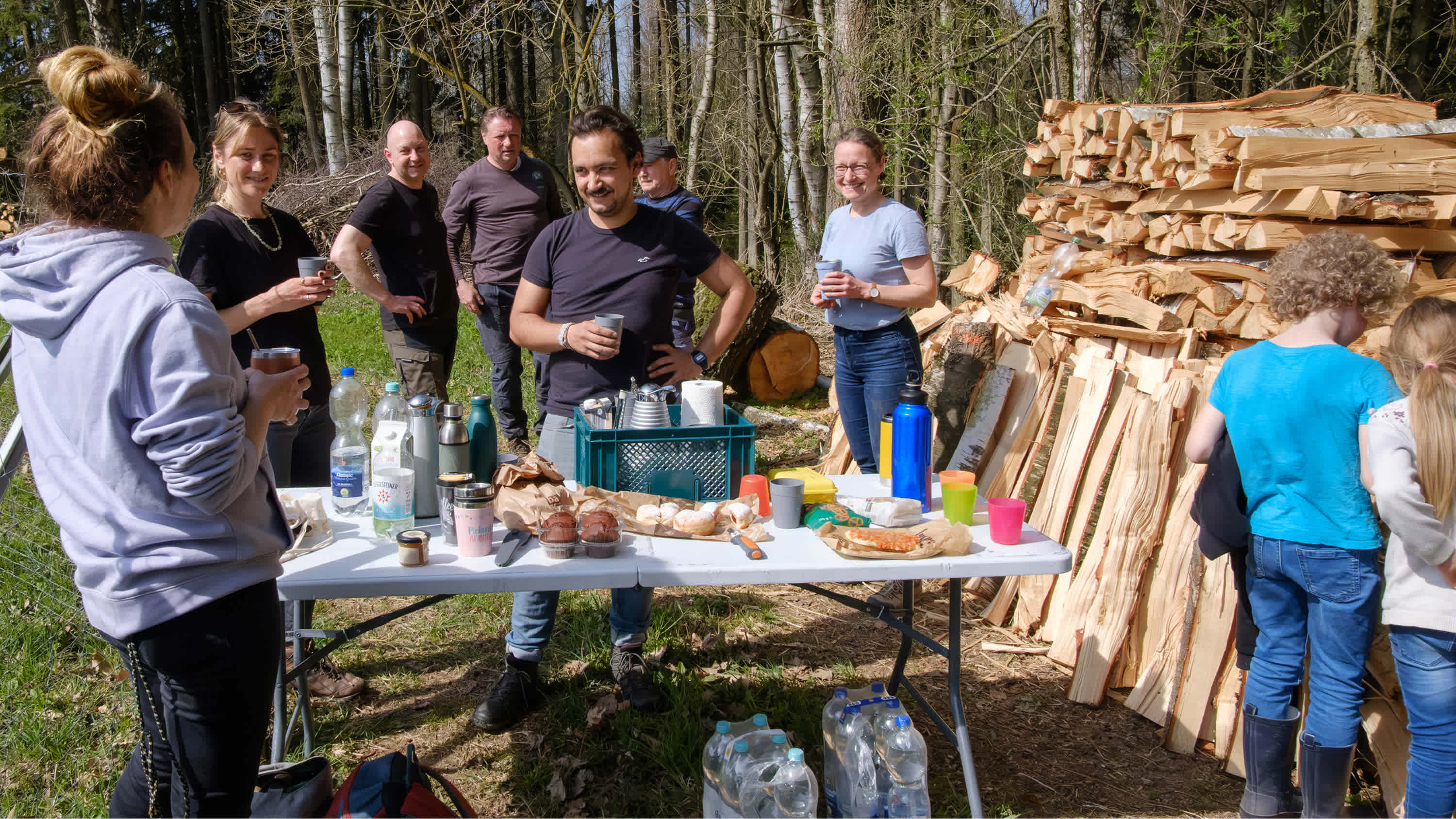 People chatting around a table with food and drinks