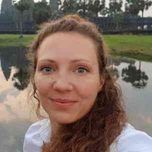 Christina vor einem Hintergrund in der Natur.