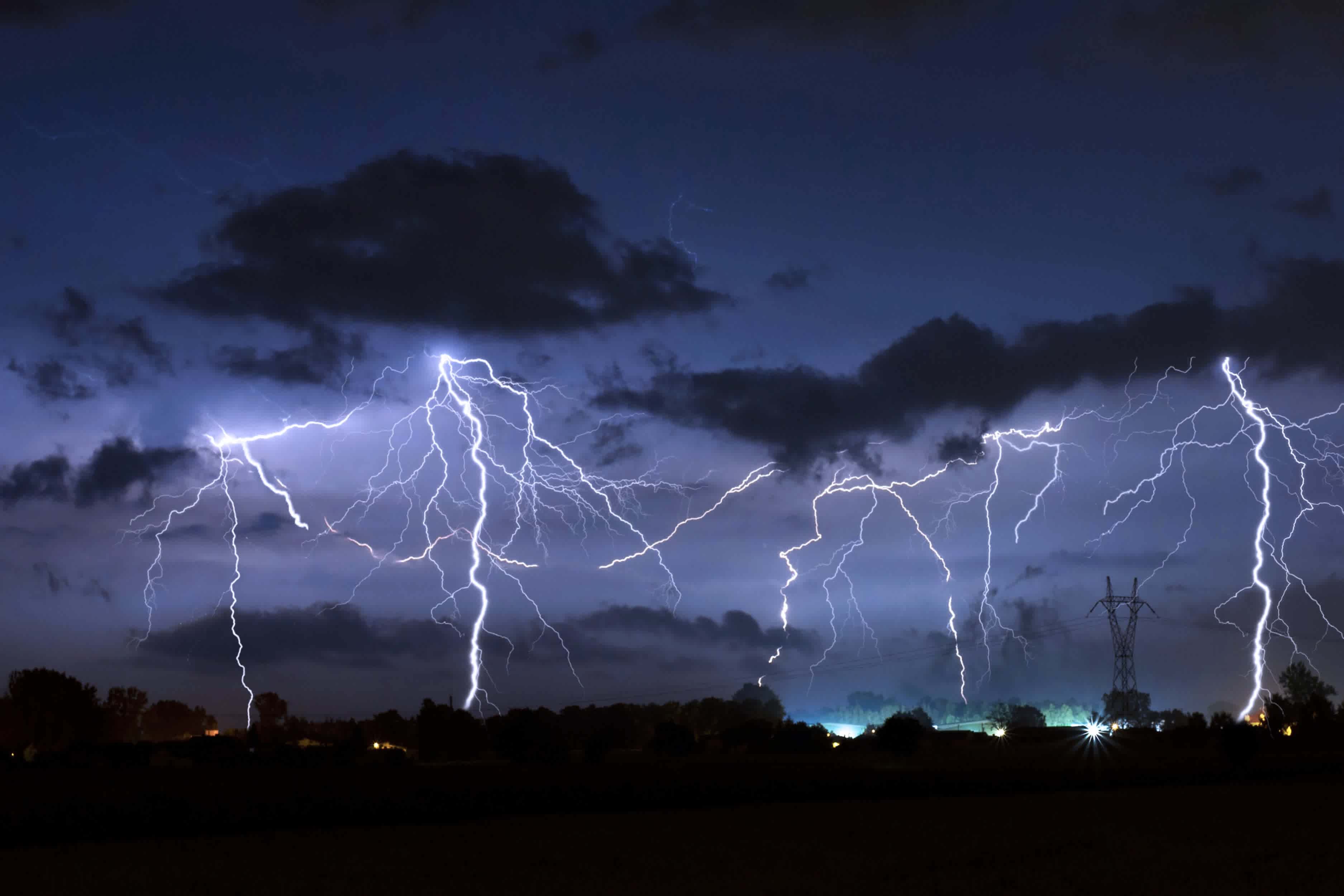 Foto eines Gewitters bei Nacht, Blitze schießen aus dem Himmel. 