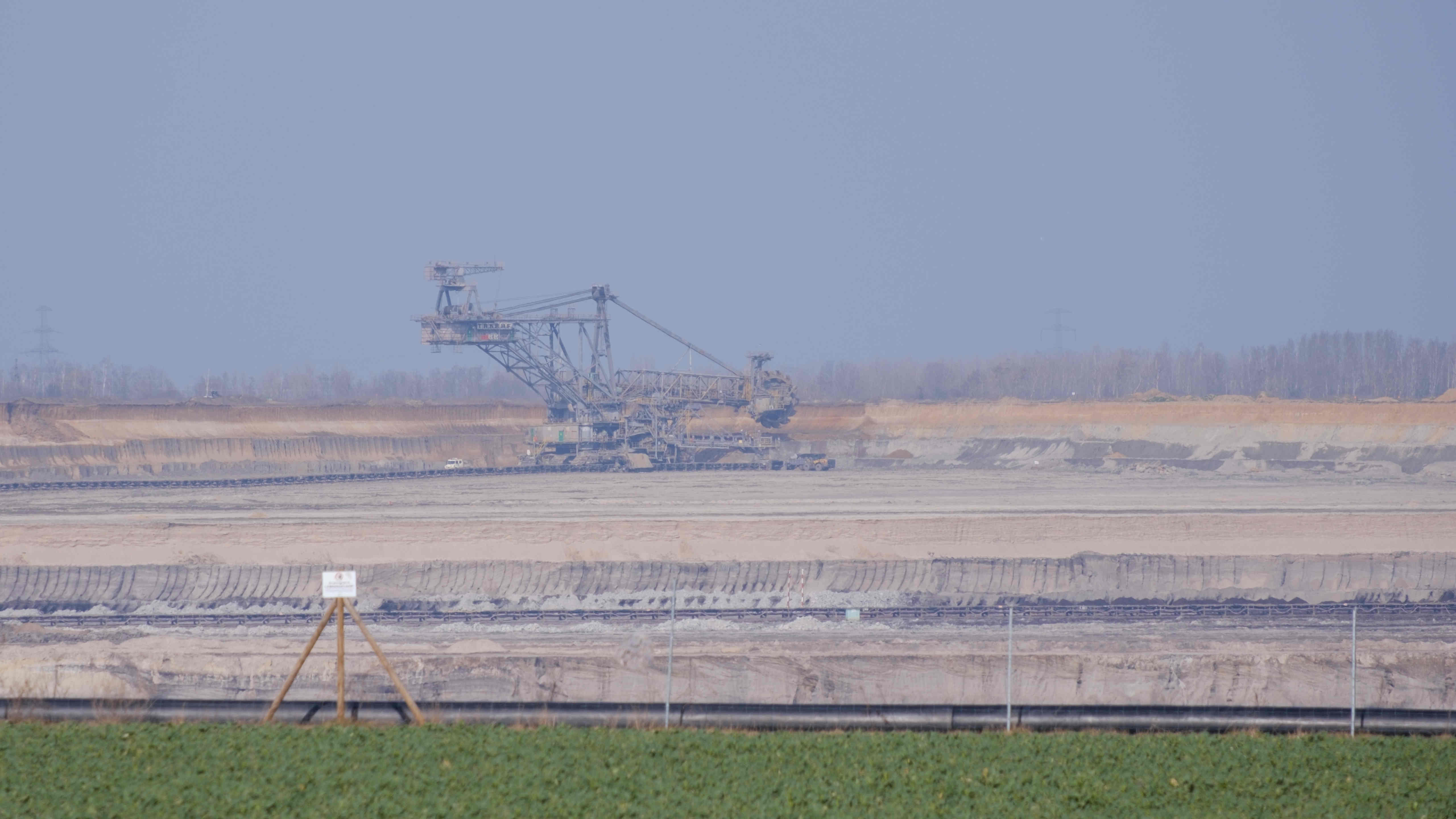 Green area with open mine and huge digger in the background