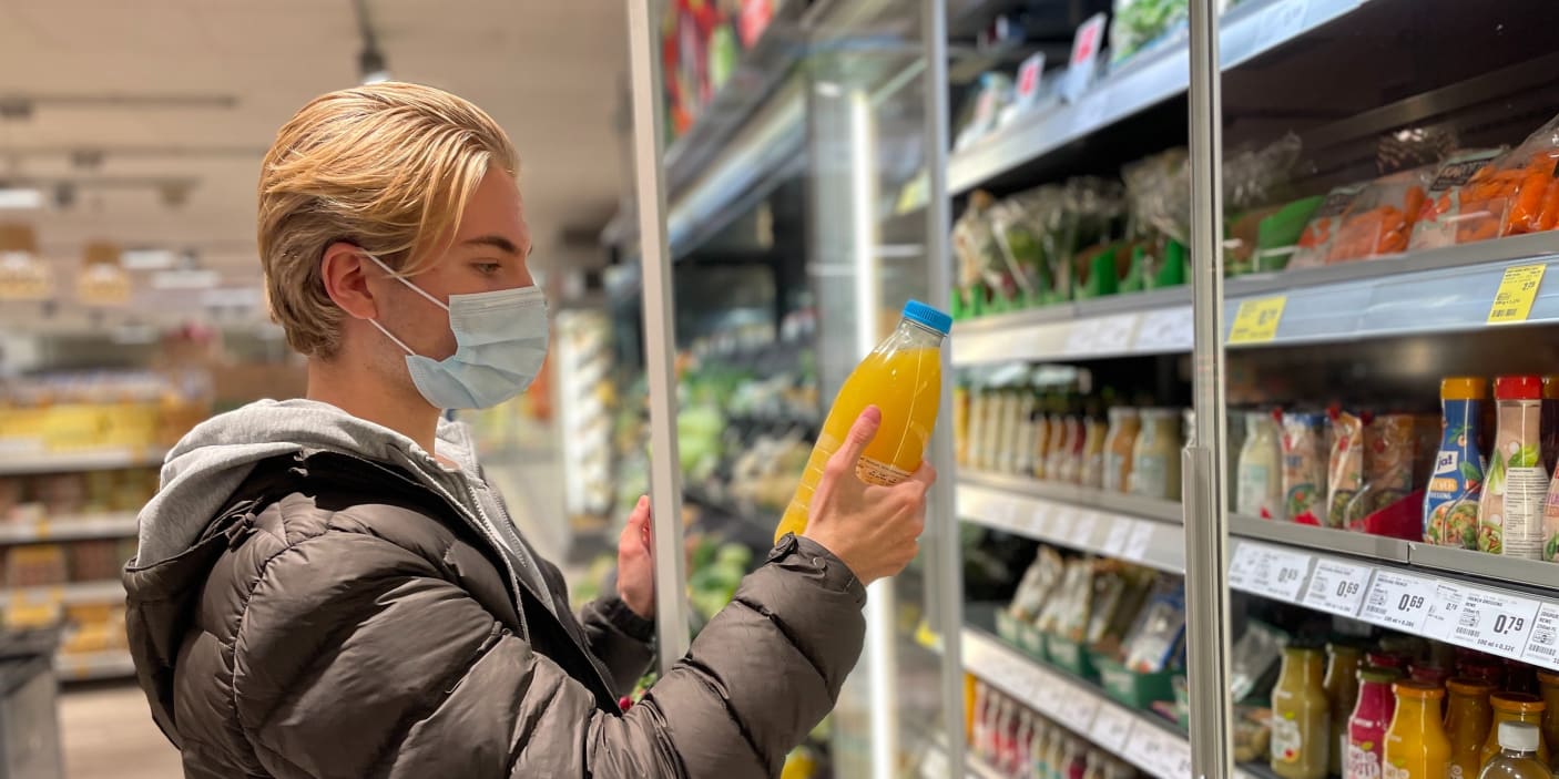 Felix schaut sich im Supermarkt eine Saftflasche an