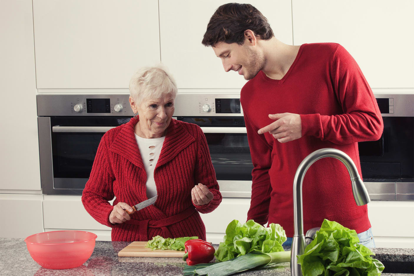 Eine ältere Frau und ein junger Mann kochen zusammen.