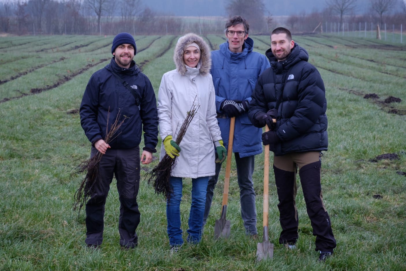 Picture of the ForTomorrow team standing in front of a afforestation area.